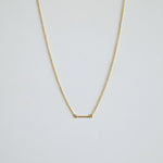 Gold necklace on a light gray background