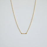 Gold necklace on a light gray background