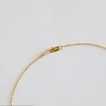Gold bracelet on a light gray background