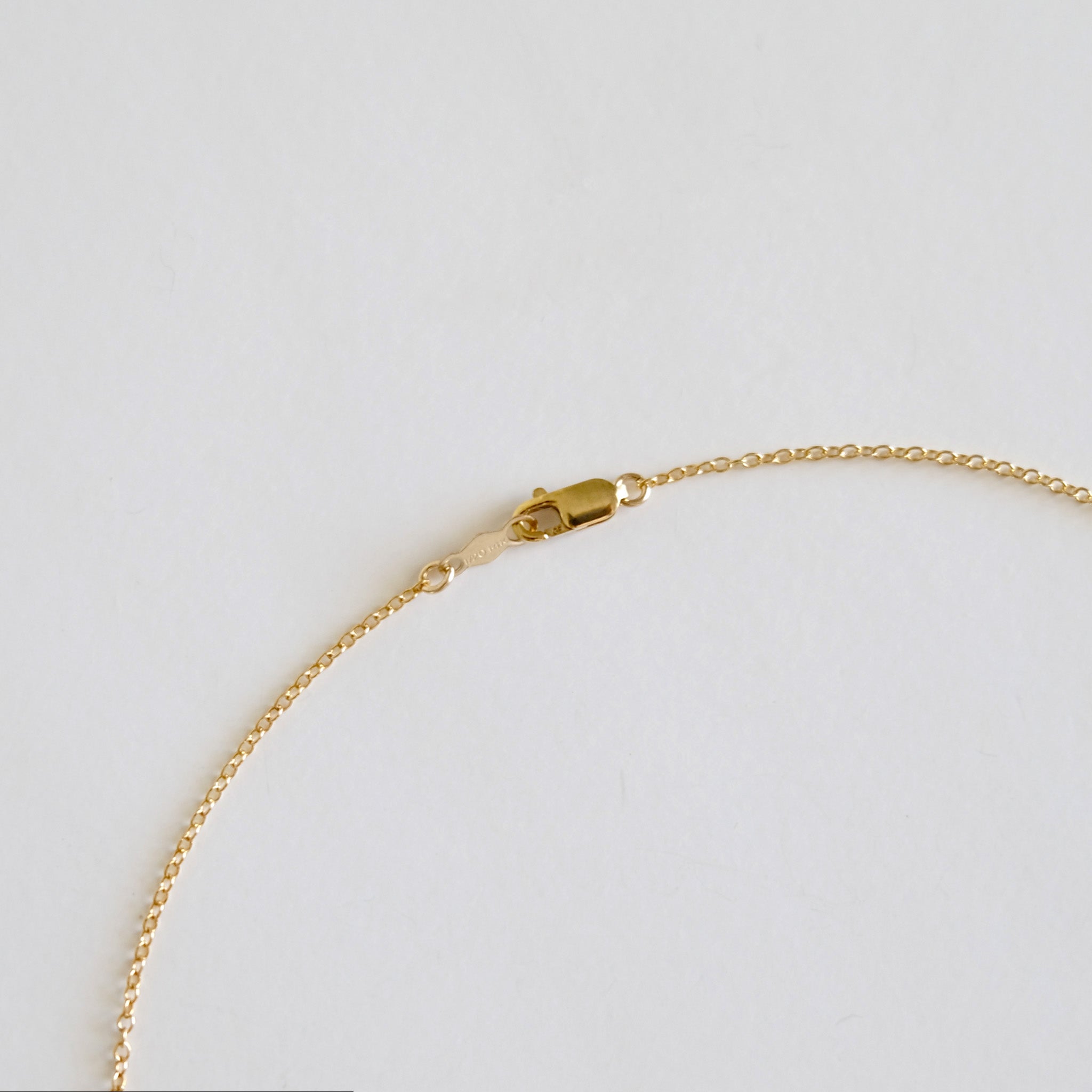 Gold bracelet on a light gray background