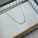 Gold necklace on a white surface with a blurred background