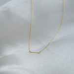 Gold necklace on a white fabric background