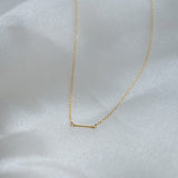 Gold necklace on a white fabric background