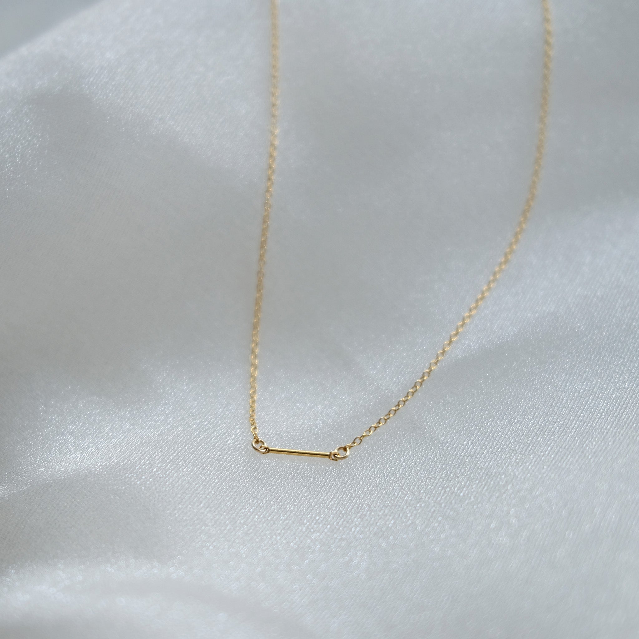 Gold necklace on a white fabric background