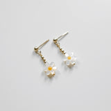 Flower-shaped earrings on a light gray background