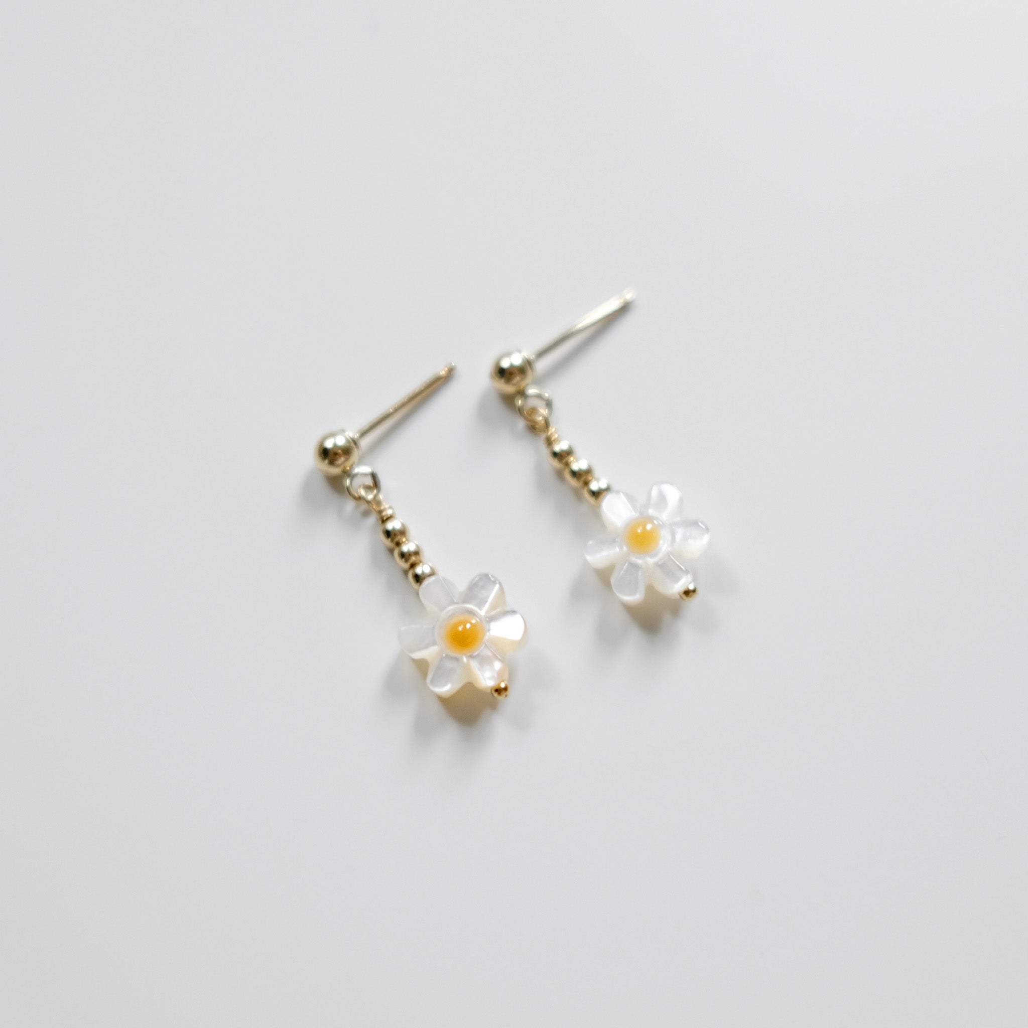 Flower-shaped earrings on a light gray background