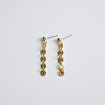 Gold chain earrings on a light gray background