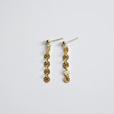 Gold chain earrings on a light gray background