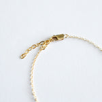 Gold bracelet with clasp on a light gray background