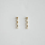 Pair of gold earrings on a light gray background