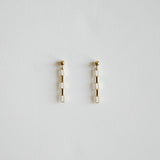 Pair of gold earrings on a light gray background