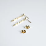 Gold stud earrings on a light gray background