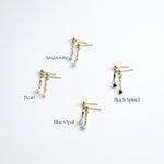 Four pairs of gold earrings with different gemstones on a white background