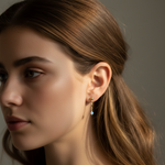 Close-up of a woman wearing an earring with a neutral background