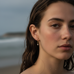 Close-up of a woman's face with wet hair against a blurred beach background