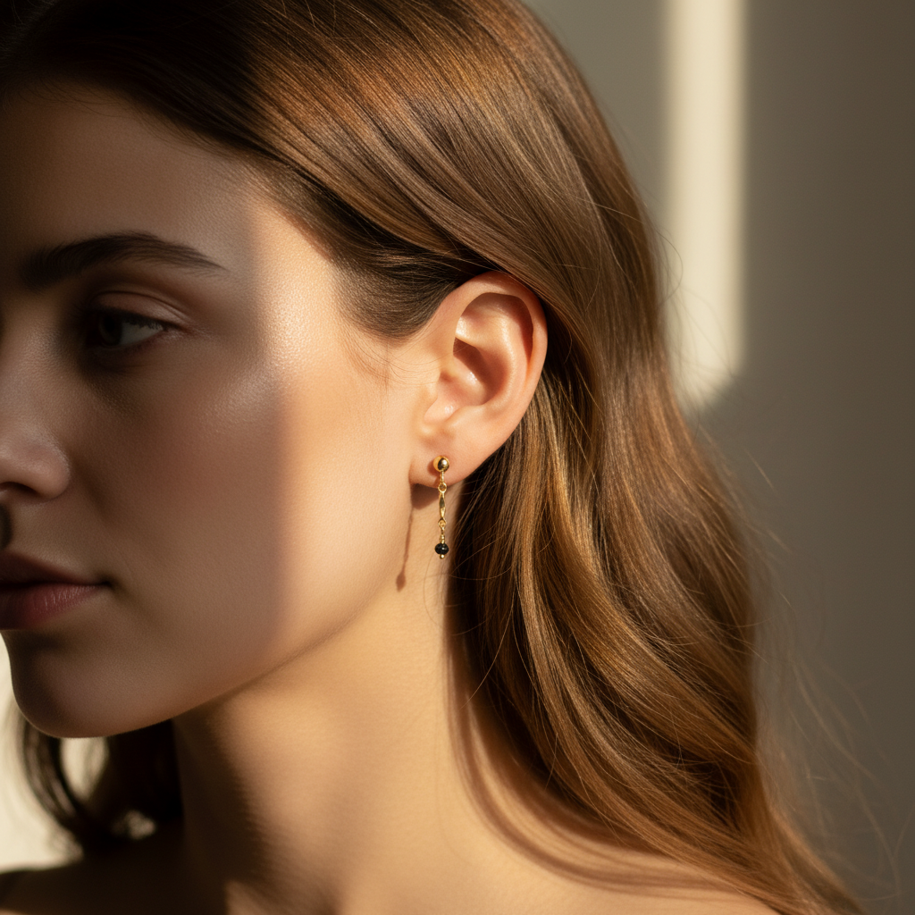 Close-up of a woman wearing gold earrings with a neutral background