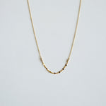 Gold necklace on a light gray background