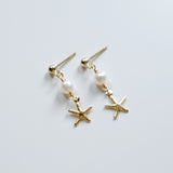 Pair of earrings with starfish and pearl designs on a light gray background