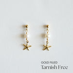 Gold-filled starfish earrings with pearls on a light gray background