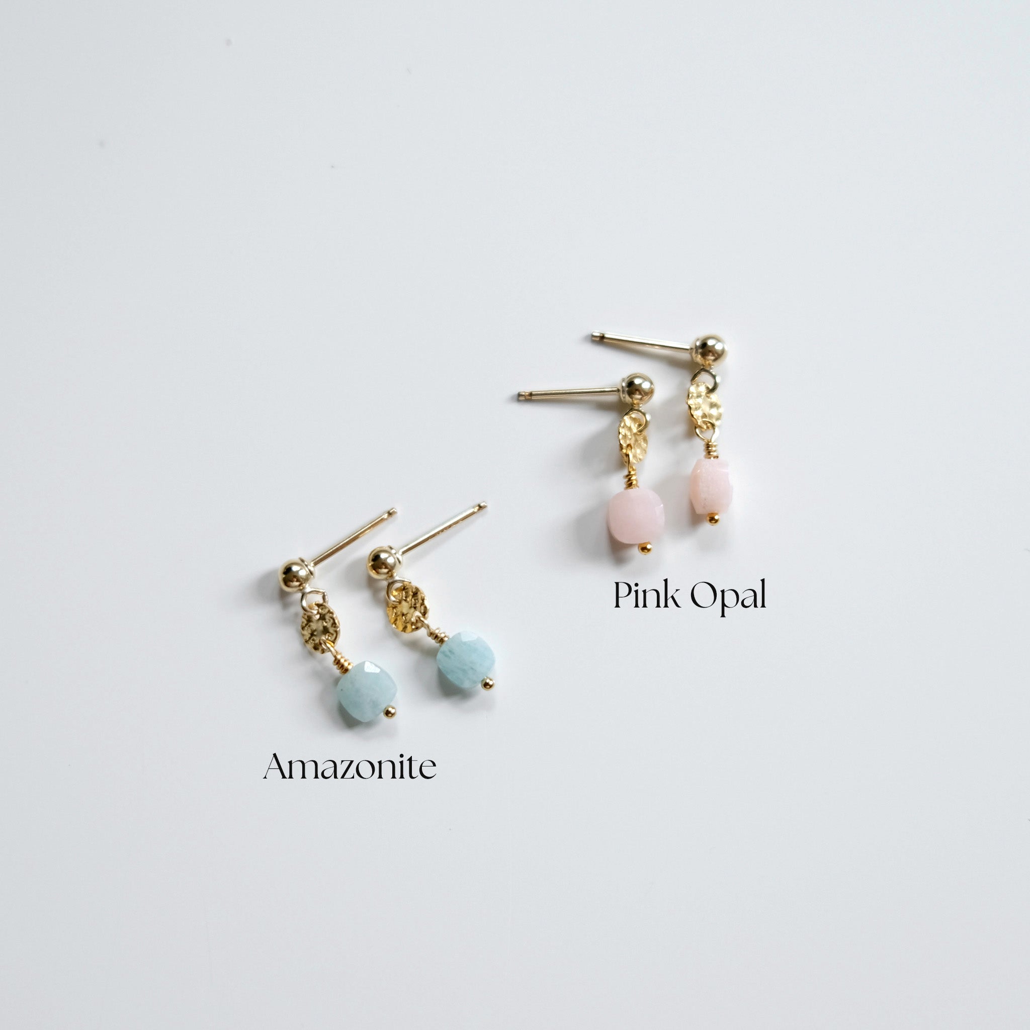 Pair of earrings with pink opal and amazonite stones on a light gray background