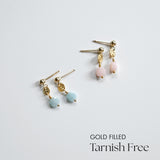 Gold-filled earrings with pink and blue beads on a light gray background