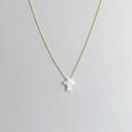 Necklace with a cross pendant on a light gray background