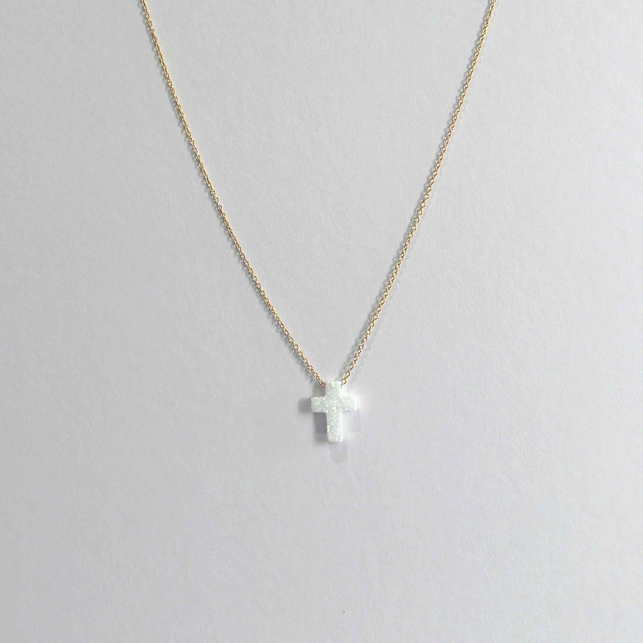 Necklace with a cross pendant on a light gray background