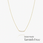 Gold-filled necklace with pearls on a white background