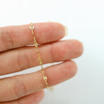 Gold chain bracelet on a person's wrist against a white background