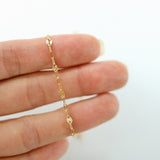 Gold chain bracelet on a person's wrist against a white background