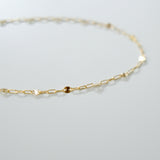 Gold chain necklace on a light gray background