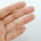 Gold chain necklace on a hand against a white background