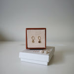 Product presentation of Celina disc Earrings in branded box, styled on white surface with clean background