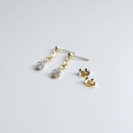 Gold earrings on a light gray background