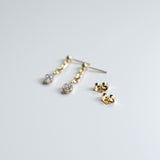 Gold earrings on a light gray background