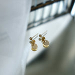 Gold earrings on a light background