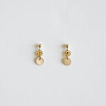 Pair of gold earrings on a light gray background