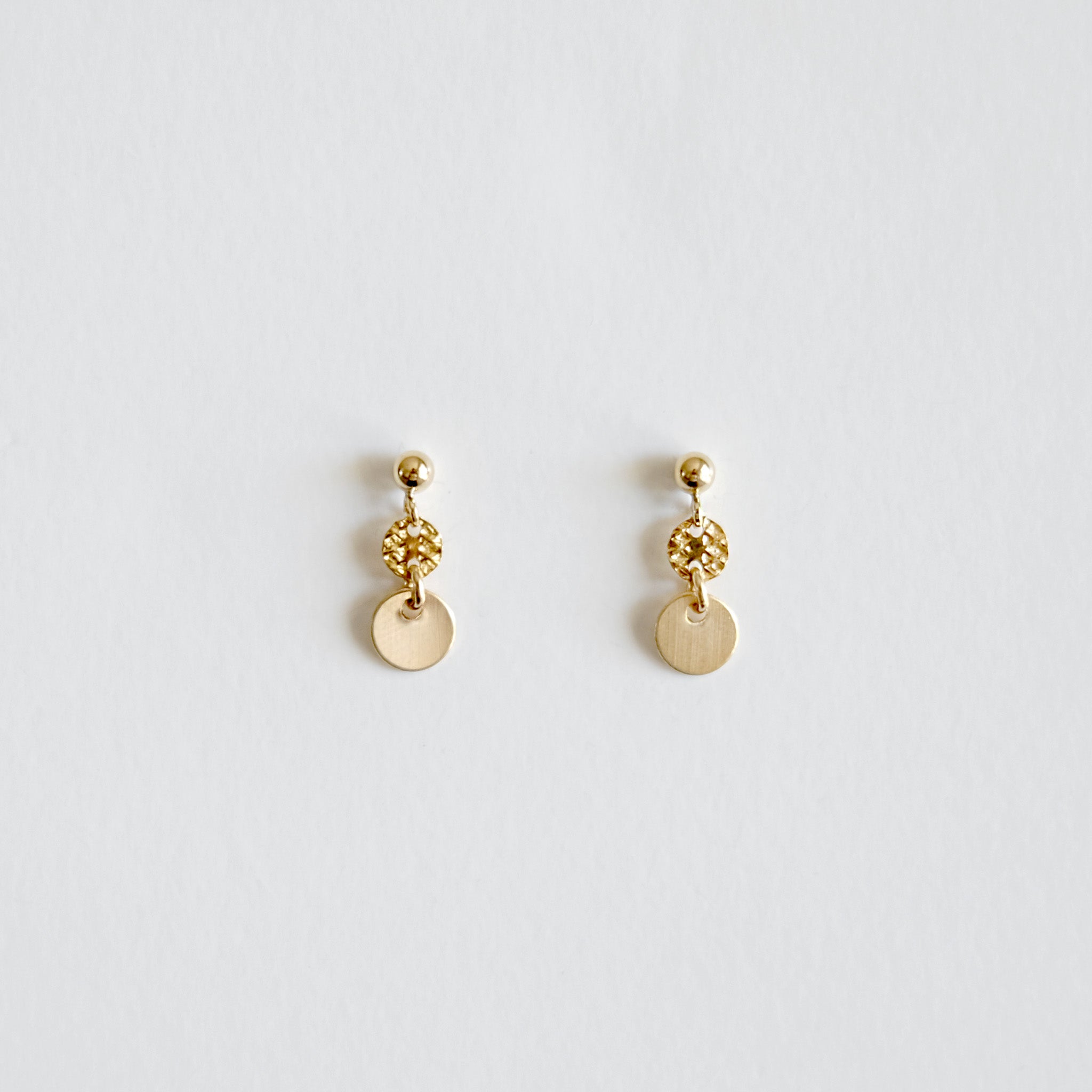 Pair of gold earrings on a light gray background