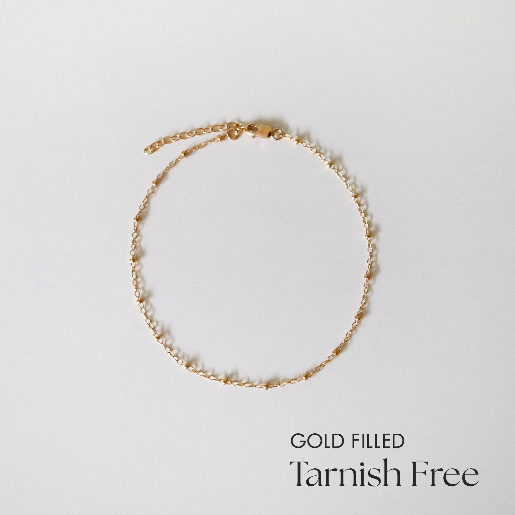 Gold-filled Dotty Chain II Anklet laid flat on white surface showing even bead spacing