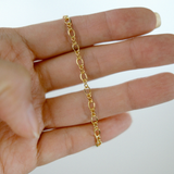 Gold chain on a hand against a white background
