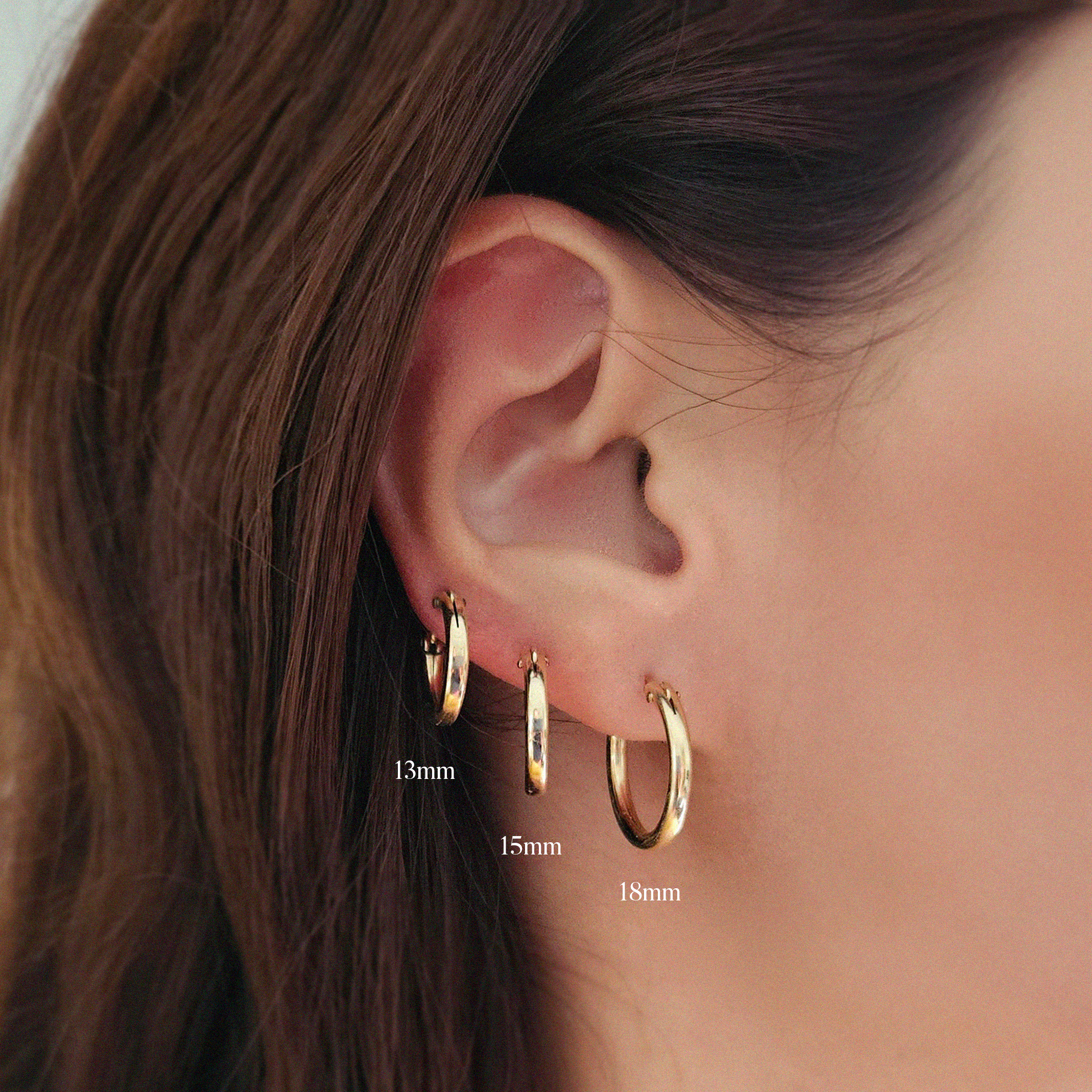 Model wearing 13mm, 15mm, and 18mm gold-filled flex hoops side by side for size comparison.