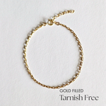 Flat lay of gold filled minimalist chain bracelet with soft lighting