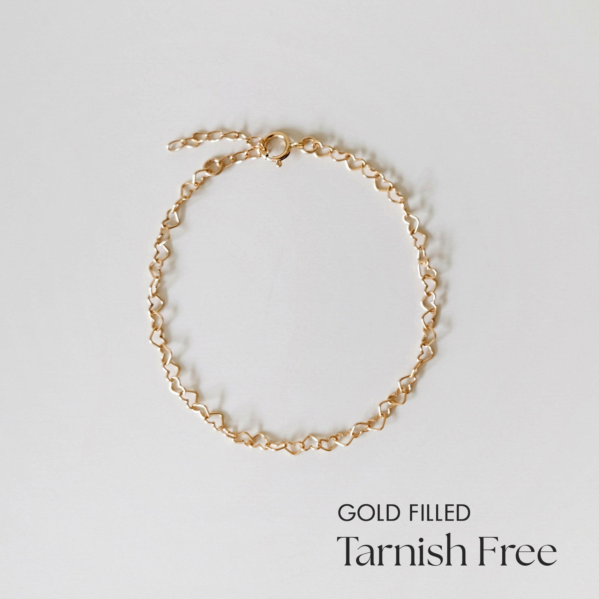 Top view of Gold Filled Linked Heart Bracelet arranged in a circle on white background