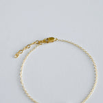 Gold bracelet on a light gray background