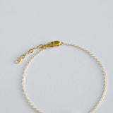 Gold bracelet on a light gray background