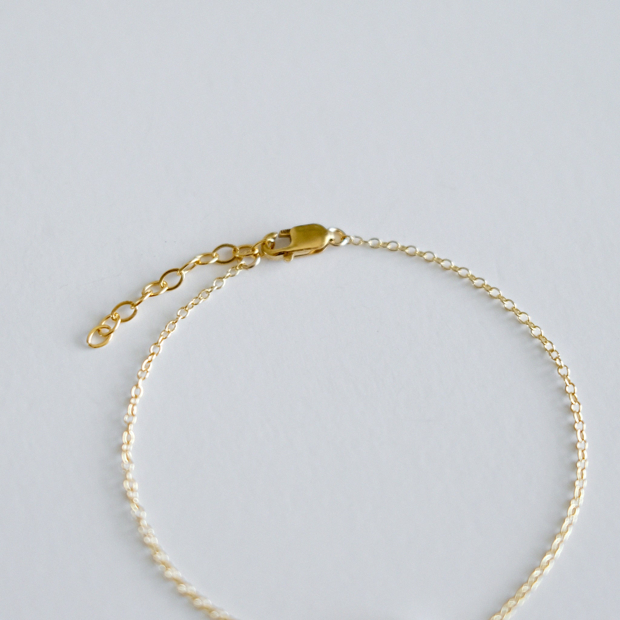 Gold bracelet on a light gray background