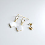 Pair of clover pendant earrings with butterfly back closures on a light gray background