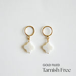 Gold-filled clover pendant earrings on a light gray background