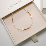 Pearl and gold beaded bracelet in a 'LAONDRIM' box on a light background