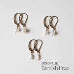 Gold-filled Olivia earrings with small, medium, and large pearls laid flat on white background